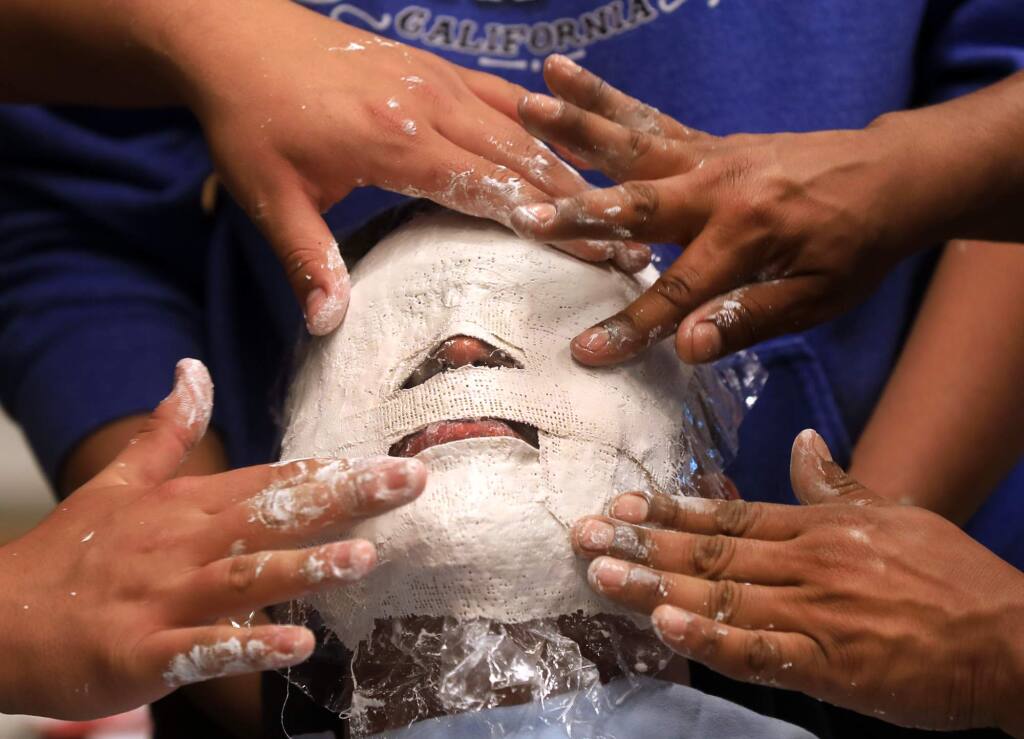 Ivan Villagomez, 16, sits patiently as a mask is made of his face, during the SRJC Native Bridge program, Monday, June 17, 2019 in Santa Rosa. (Kent Porter / The Press Democrat) 2019-