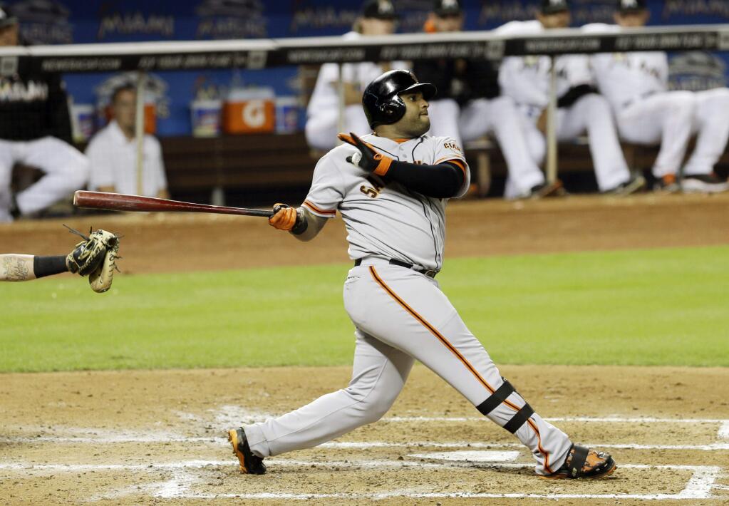 San Francisco Giants' Pablo Sandoval follows through on his three-run home run against the Miami Marlins in the fifth inning of a baseball game in Miami, Friday, July 18, 2014. Joe Panik and Buster Posey scored on the home run. (AP Photo/Alan Diaz)