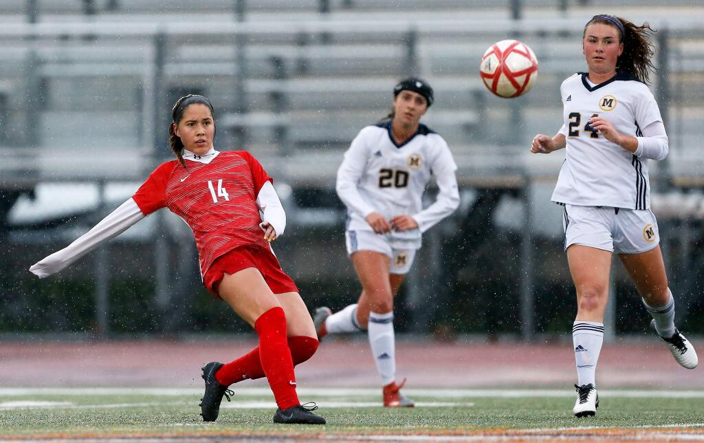 Montgomery's Cindy Arteaga, left, sends a pass across midfield during the first half of the CIF NorCal regional tournament match between Menlo and Montgomery high schools on Tuesday, February 26, 2019. (Alvin Jornada / The Press Democrat)