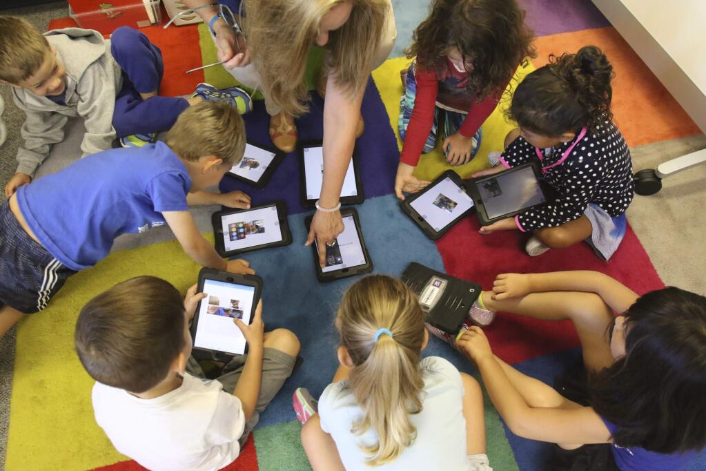 Inez Reed works with her students to take photos on new iPads at Grant Elementary School in Petaluma on Tuesday, September 1, 2015. Students are, clockwise from Reed, Amelia Walters, Siena Calandrella, Jasmine Pierpoint, Emily Loveman, Diesel Ganley, Andy Westberg, and Tio Griffo.(SCOTT MANCHESTER/ARGUS-COURIER STAFF)