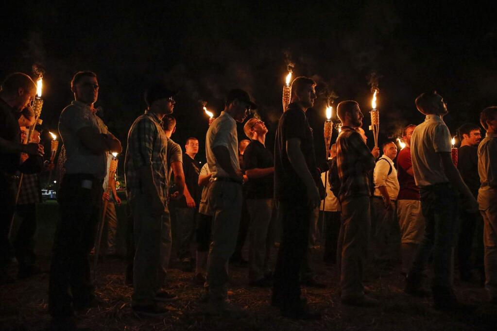 FILE - In this Aug. 11, 2017, file photo, multiple white nationalist groups march with torches through the University of Virginia campus in Charlottesville, Va. (Mykal McEldowney/The Indianapolis Star via AP, File)