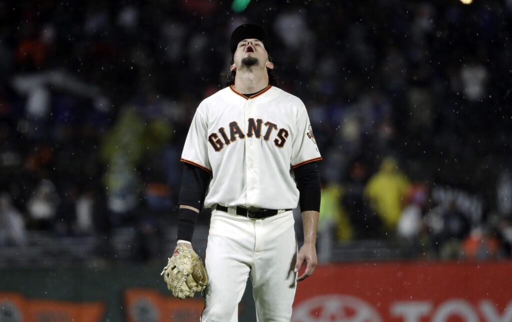 San Francisco Giants' Jarrett Parker looks up at the rain during the first inning of a baseball game against the Los Angeles Dodgers Monday, Sept. 11, 2017, in San Francisco. (AP Photo/Marcio Jose Sanchez)