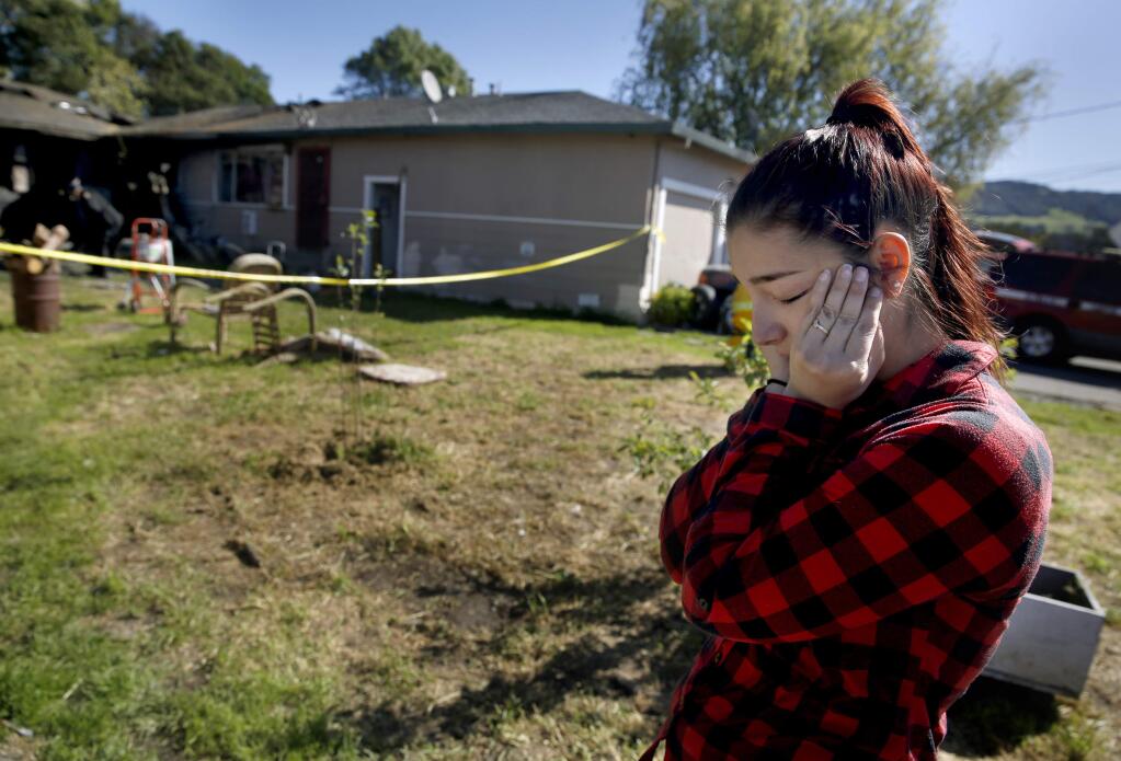 Alexandra Peterson, who had been living in the four-unit apartment with her daughter Esmeralda Zuniga, 2, reacts as investigators look for evidence in the remains on Barbara Drive that burned. Photo in Santa Rosa, on Monday, March 28, 2016. (BETH SCHLANKER/ The Press Democrat)