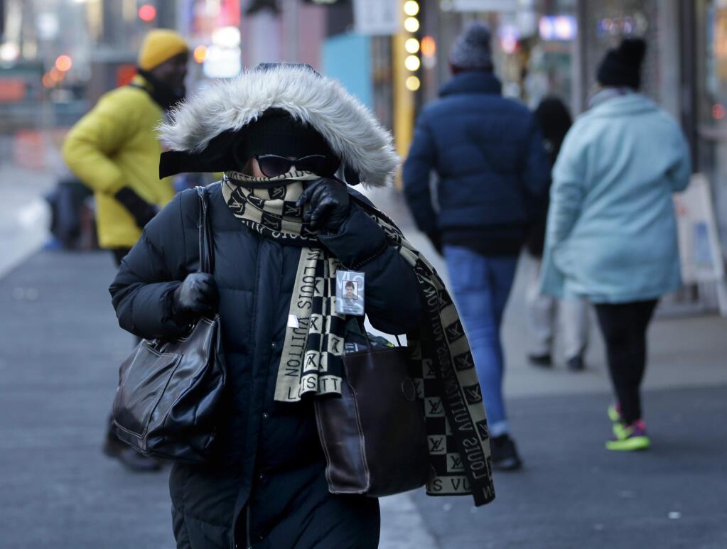 Pedestrians bundled up against the cold hurry though the streets in Times Square in New York, Thursday, Jan. 8, 2015. Dangerously cold air has sent temperatures plummeting into the single digits around the U.S., with wind chills driving them even lower. (AP Photo/Seth Wenig)