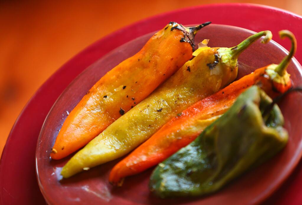 Seared and peeled New Mexico chiles, three on left, and a Poblano chili. (CHRISTOPHER CHUNG/ PD)