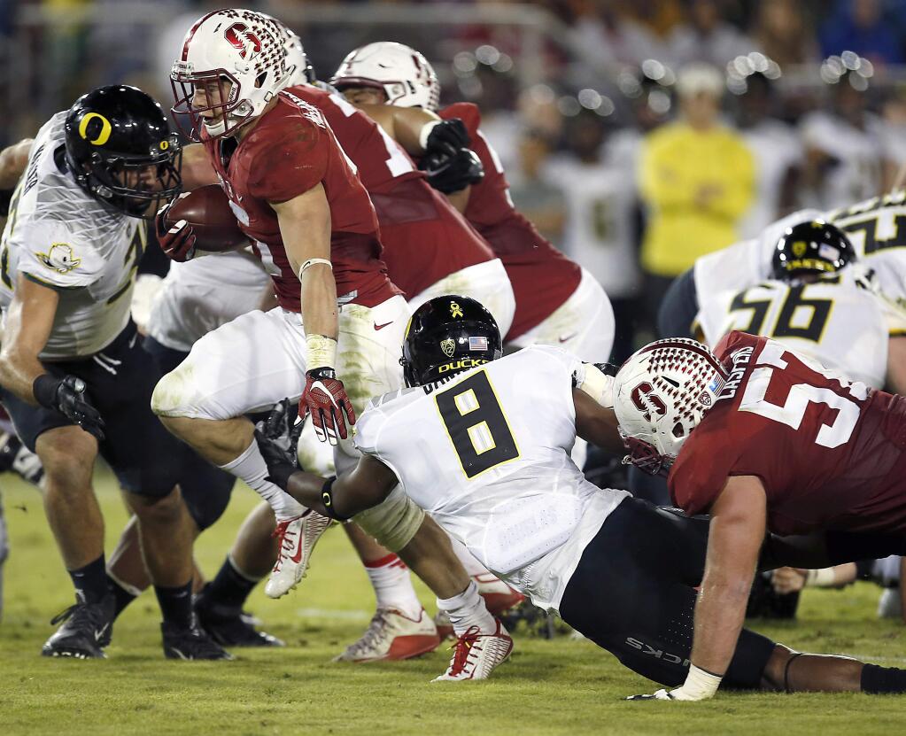 Stanford running back Christian McCaffrey (5) rushes past Oregon defensive back Reggie Daniels (8) for a touchdown during the first half Saturday, Nov. 14, 2015, in Stanford. (AP Photo/Tony Avelar)