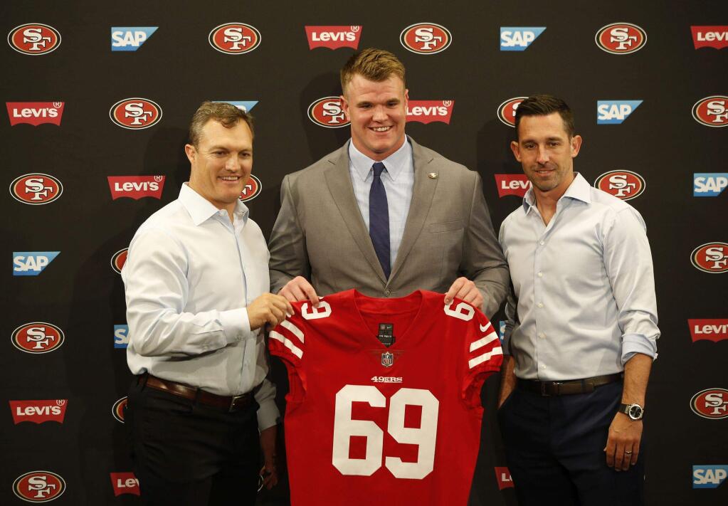 49ers general manager John Lynch, left, introduces first-round pick Mike McGlinchey, center, with coach Kyle Shanahan, right, during an NFL football news conference, Friday, April 27, 2018, in Santa Clara, Calif. (AP Photo/Josie Lepe )