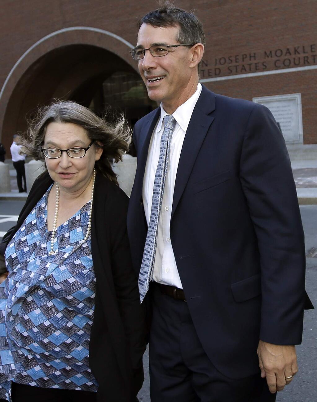 Michael Center, right, former men's tennis coach at the University of Texas at Austin, departs federal court with an unidentified woman, Wednesday, April 24, 2019, in Boston, after he pled guilty to charges in a nationwide college admissions bribery scandal. (AP Photo/Steven Senne)