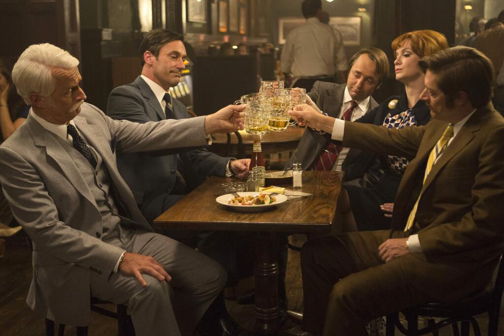 This image released by AMC shows, from left, John Slattery as Roger Sterling, Jon Hamm as Don Draper, Vincent Kartheiser as Pete Campbell, Christina Hendricks as Joan Harris and Kevin Rahm as Ted Chaough, in a scene from the final season of 'Mad Men.' The series finale airs on Sunday. (Justina Mintz/AMC via AP)