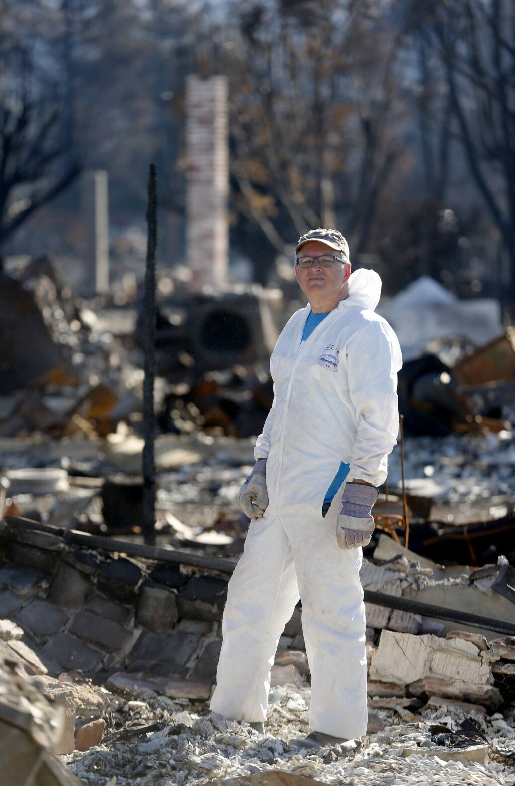 Cartoonist Brian Fies poses for a portrait while looking through the rubble of his home in Mark West Estates in the Larkfield-Wikiup area of Santa Rosa, on Wednesday, October 25, 2017. (BETH SCHLANKER/ The Press Democrat)