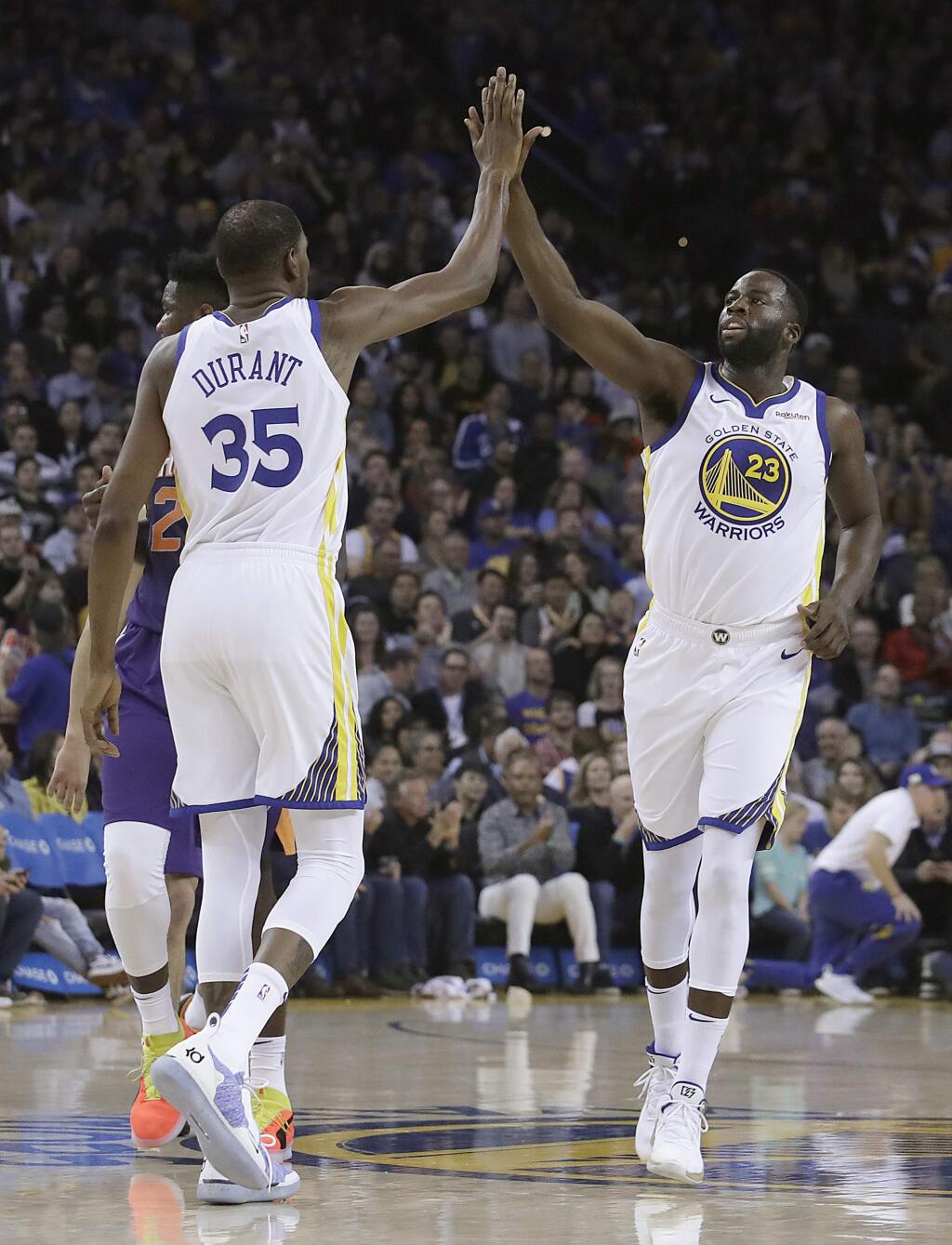 Golden State Warriors forward Kevin Durant, left, celebrates with forward Draymond Green during the first half against the Phoenix Suns in Oakland, Monday, Oct. 22, 2018. (AP Photo/Jeff Chiu)