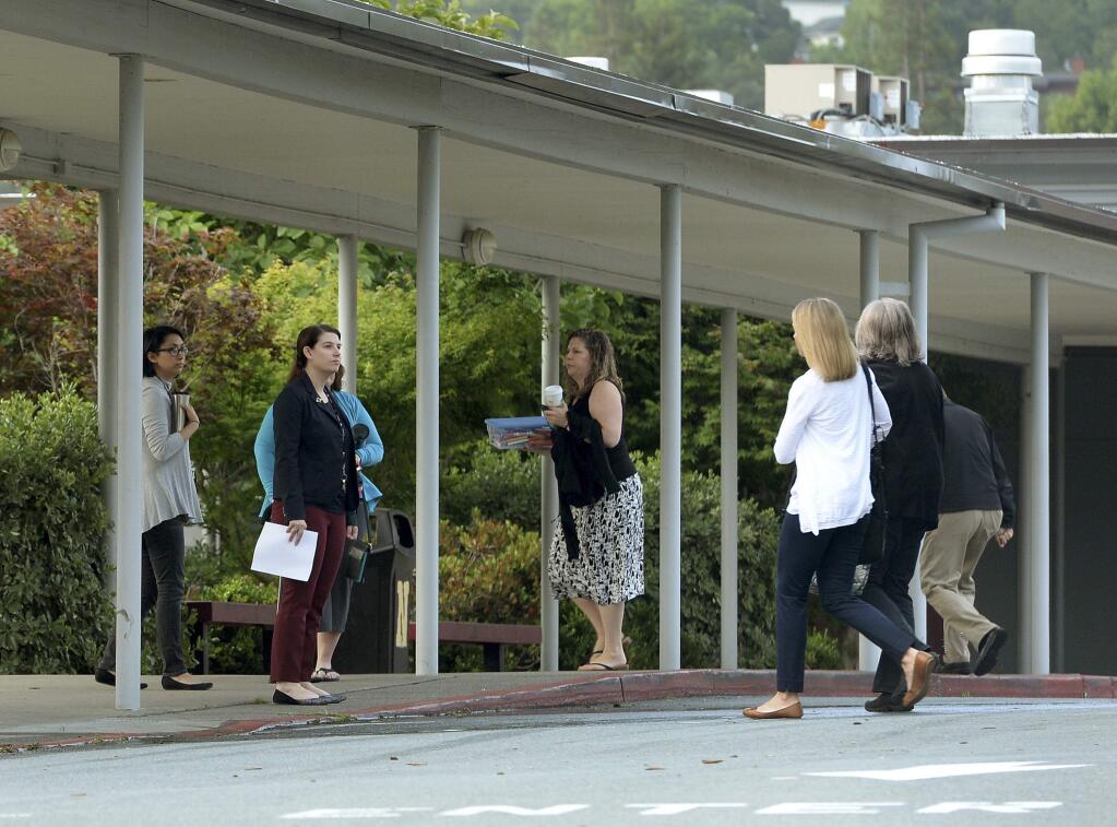 Novato High School staff members arrive at work Thursday, May 26, 2016, following at attack on two students. Attackers shot two students Wednesday near the San Francisco Bay Area high school, killing one and sending another to a hospital in an incident that prompted the closing of the campus to students. (Robert Tong/Marin Independent Journal via AP)