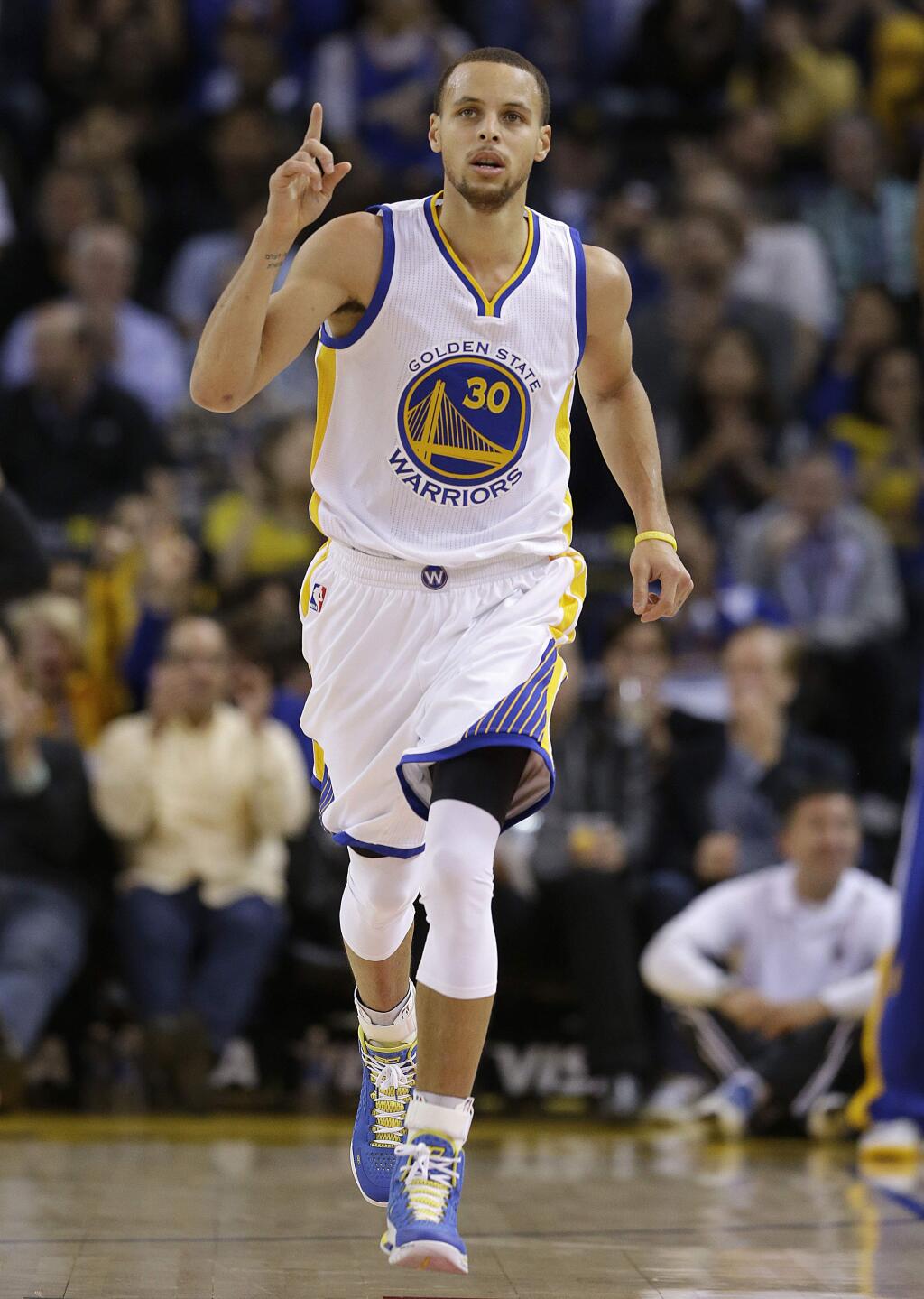 Golden State Warriors guard Stephen Curry celebrates after making a 3-point basket against the Miami Heat during the first half of an NBA basketball game in Oakland, Calif., Wednesday, Jan. 14, 2015. (AP Photo/Jeff Chiu)