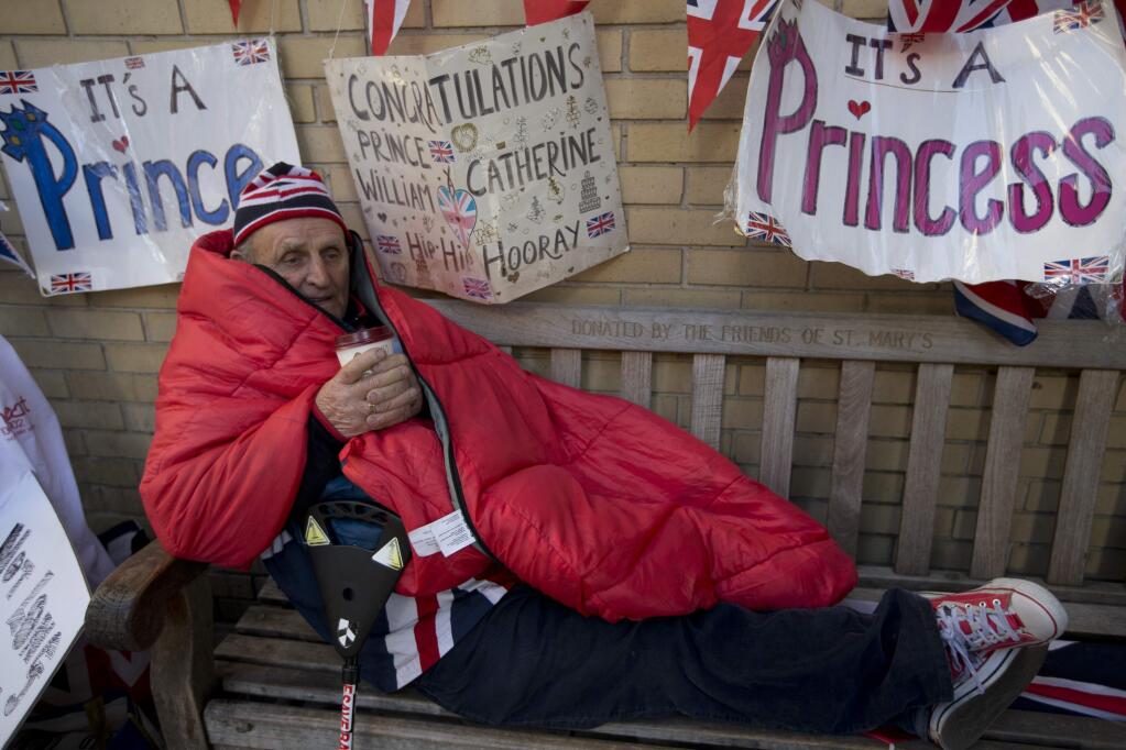 Royal fan Terry Hutt enjoys a hot drink as he celebrates his 80th birthday outside the Lindo Wing of St Mary's Hospital, as he continues his vigil waiting for Kate, Duchess of Cambridge to arrive at the hospital, in London, Thursday, April, 30, 2015. Kate is due to give birth late April to her second child, at St Mary's. (AP Photo/Alastair Grant)