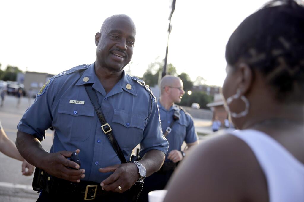 In this Aug. 19, 2014 file photo, Missouri Highway Patrol Capt. Ron Johnson meets with residents while walking the streets of Ferguson, Mo. Under Johnson's measured guidance, calm has been restored in Ferguson as the violent protests have ended, shops and restaurants along West Florissant are slowly getting back to business. (AP Photo/Jeff Roberson, File)