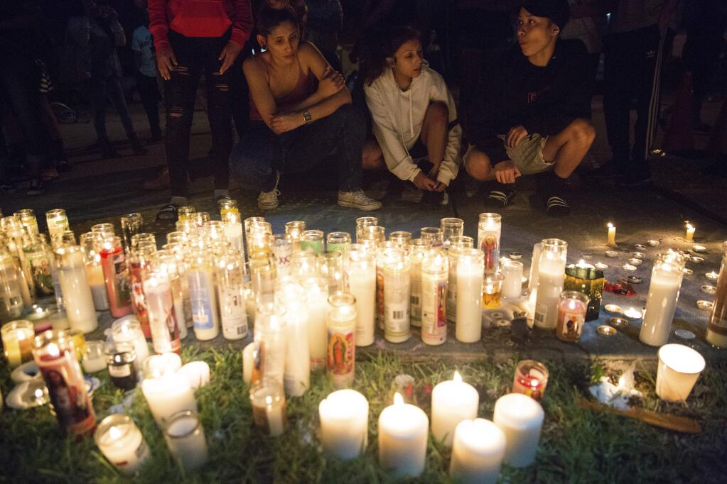 In this Tuesday, June 19, 2018 photo, fans and community members gather at the vigil for rap singer XXXTentacion in Deerfield Beach, Fla., near the site where the troubled rapper-singer was killed the day before. The 20-year-old rising star, whose real name is Jahseh Dwayne Onfroy, was shot outside the motorcycle dealership on Monday, June 18, when two armed suspects approached him, authorities said. (Tuesday, June 19, 2018,/South Florida Sun-Sentinel via AP)