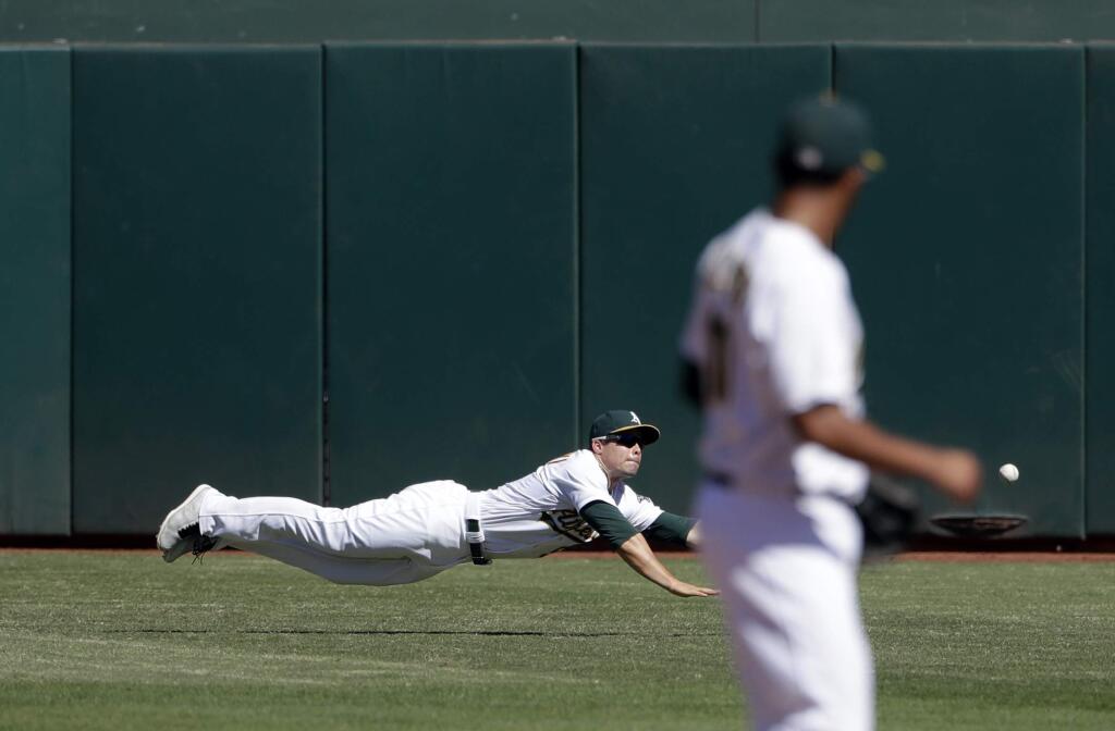 Oakland Athletics center fielder Jake Smolinski dives but can't catch a line drive for a single from Texas Rangers' Jurickson Profar during the fifth inning Saturday, Sept. 24, 2016, in Oakland. (AP Photo/Marcio Jose Sanchez)