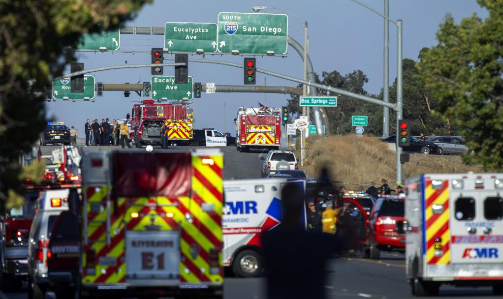 Authorities work the scene where a shootout near a freeway killed a California Highway Patrol officer and wounded two others before the gunman was fatally shot, Monday, Aug. 12, 2019, in Riverside, Calif. (Terry Pierson/The Orange County Register via AP)
