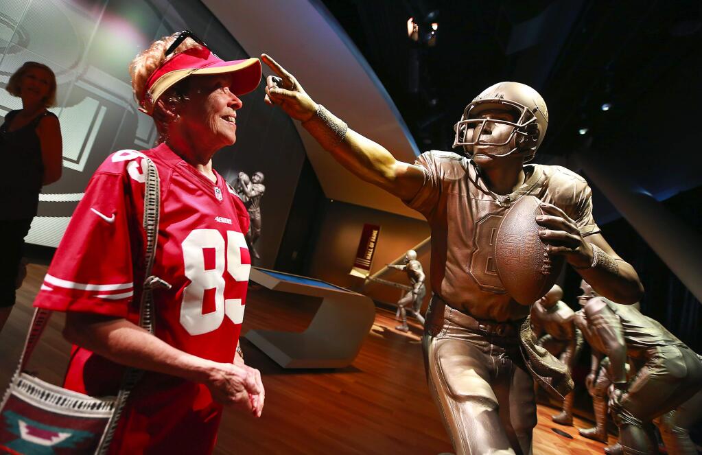 A life-size stature of Steve Young points to Jackie Dickey of Fremont in the Hall of Fame gallery at the 49ers Museum inside the new Levi's Stadium in Santa Clara. All 22 49er Hall of Famers are depicted in classic poses from their careers.