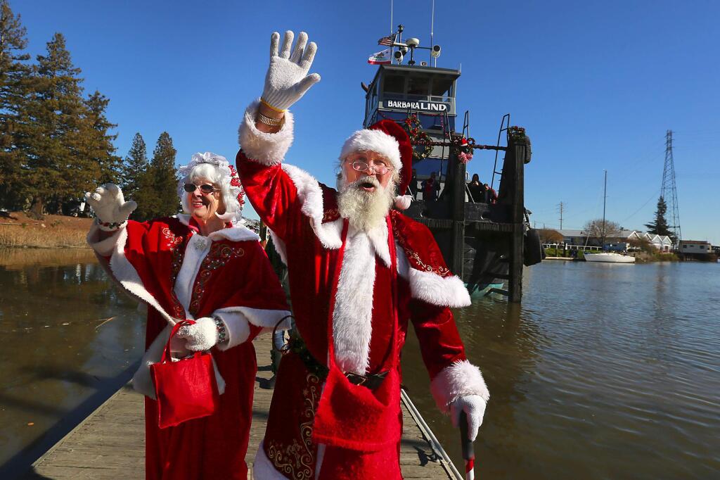 Santa and Mrs. Claus arrived aboard the tugboat Barbara Lind at the turning basin in Petaluma on Saturday. (JOHN BURGESS / The Press Democrat)