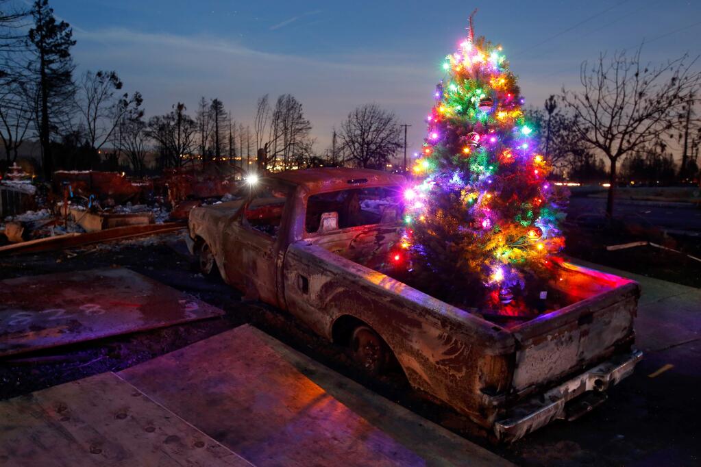 A Christmas tree, that was decorated by a group of volunteers led by Ronnie Duvall, sits in the bed of a pickup truck on Rita Place that was destroyed by the Tubbs Fire, in the Coffey Park neighborhood of Santa Rosa, California on Monday, December 11, 2017. (Alvin Jornada / The Press Democrat)