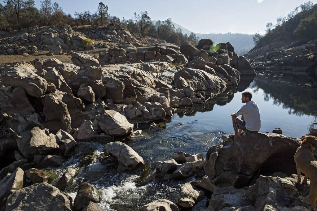 Sean Lodge sits by the San Joaquin River near his childhood home, which would be flooded by the proposed Temperance Flat reservoir. (MAX WHITTAKER / New York Times)