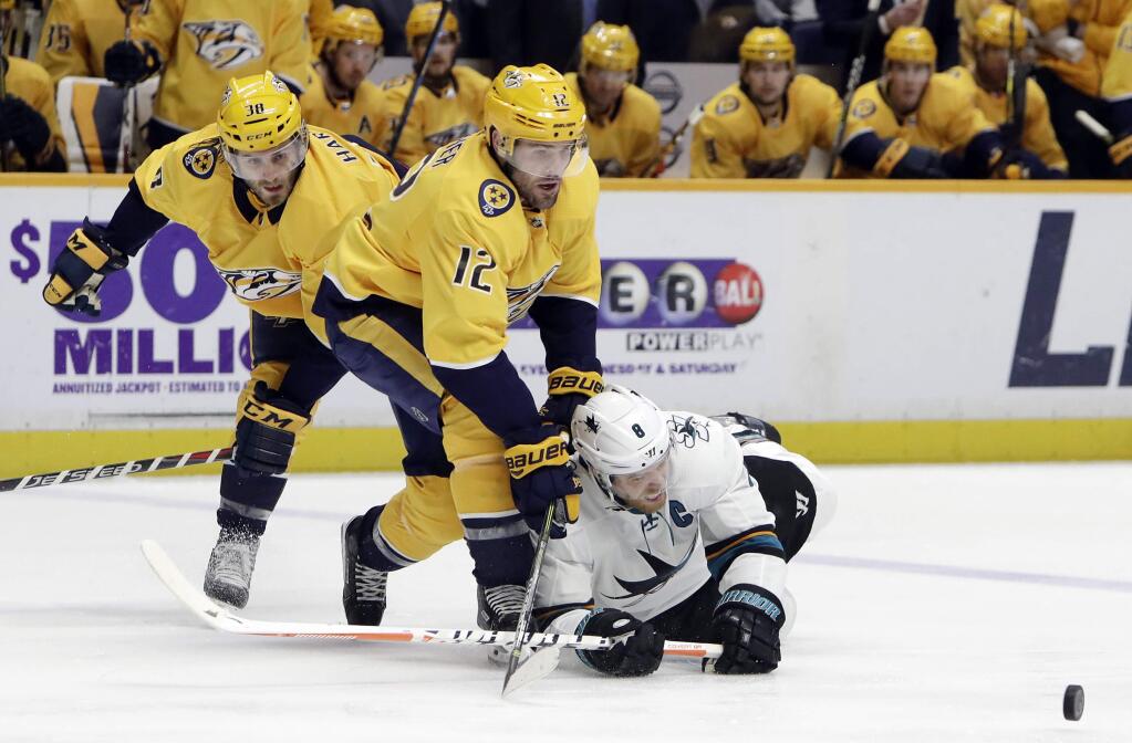 San Jose Sharks center Joe Pavelski (8) falls as he chases the puck with Nashville Predators center Mike Fisher (12) and right wing Ryan Hartman (38) in the first period Thursday, March 29, 2018, in Nashville, Tenn. (AP Photo/Mark Humphrey)