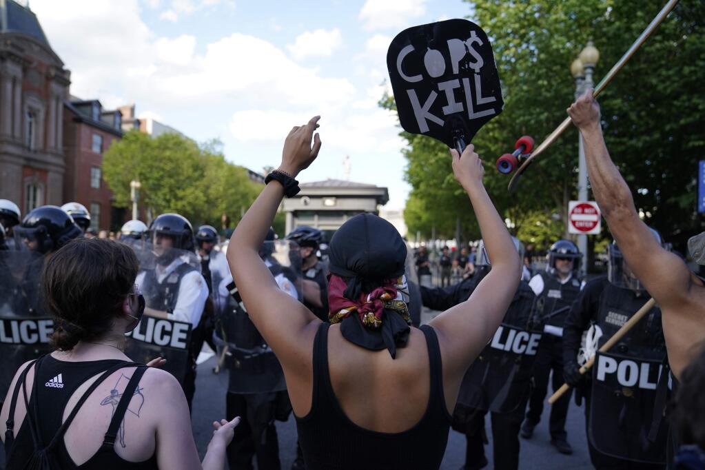 Demonstrators vent to police in riot gear as they protest the death of George Floyd, Saturday, May 30, 2020, near the White House in Washington. Floyd died after being restrained by Minneapolis police officers. (AP Photo/Evan Vucci)