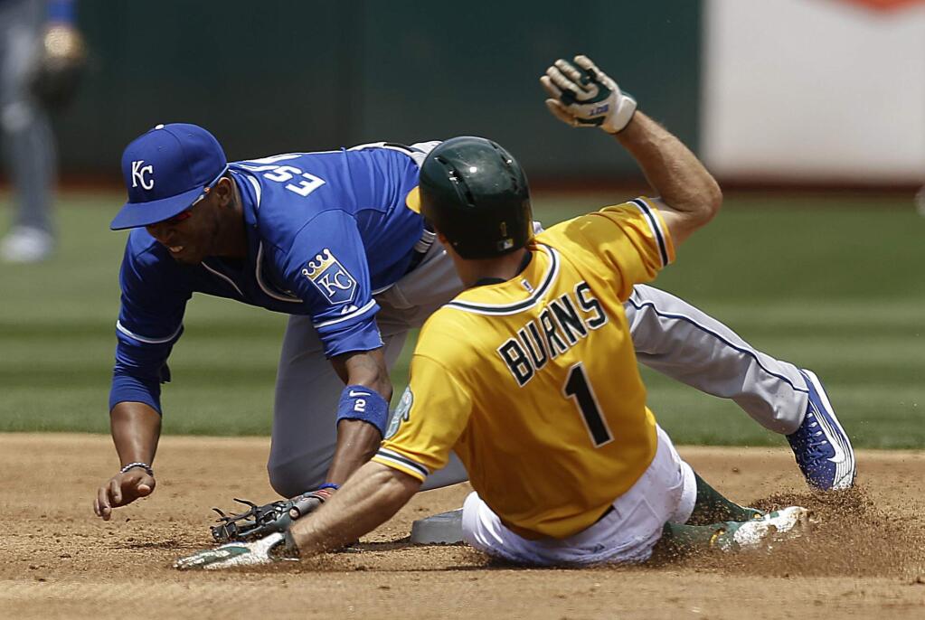 Kansas City Royals Alcides Escobar, left, tags out Oakland Athletics' Billy Burns (1) in the third inning of a baseball game Sunday, June 28, 2015, in Oakland, Calif. Burns was forced out on a single by Oakland's Eric Sogard. (AP Photo/Ben Margot)