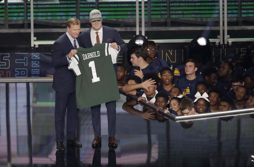 Commissioner Roger Goodell, left, presents Southern California's Sam Darnold with his New York Jets jersey during the first round of the NFL football draft, Thursday, April 26, 2018, in Arlington, Texas. (AP Photo/Eric Gay)