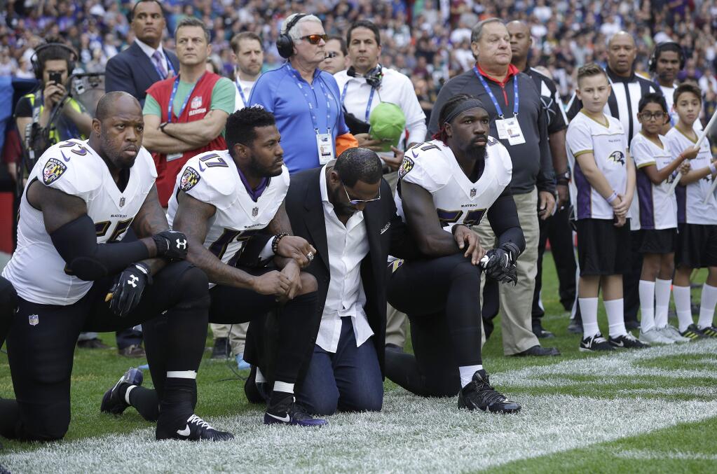 Baltimore Ravens outside linebacker Terrell Suggs, from left, Mike Wallace, former player Ray Lewis and inside linebacker C.J. Mosley kneel down during the playing of the U.S. national anthem before an NFL football game between the Jacksonville Jaguars and the Ravens at Wembley Stadium in London, Sunday Sept. 24, 2017. (AP Photo/Matt Dunham)