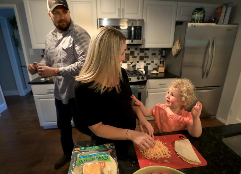 Leah Garzini, 2, talks with her parents Kaitlin and Coddy Garzini as they prepare the evening meal at their newly purchased home in Santa Rosa, Wednesday, April 10, 2019. (Kent Porter / Press Democrat) 2019