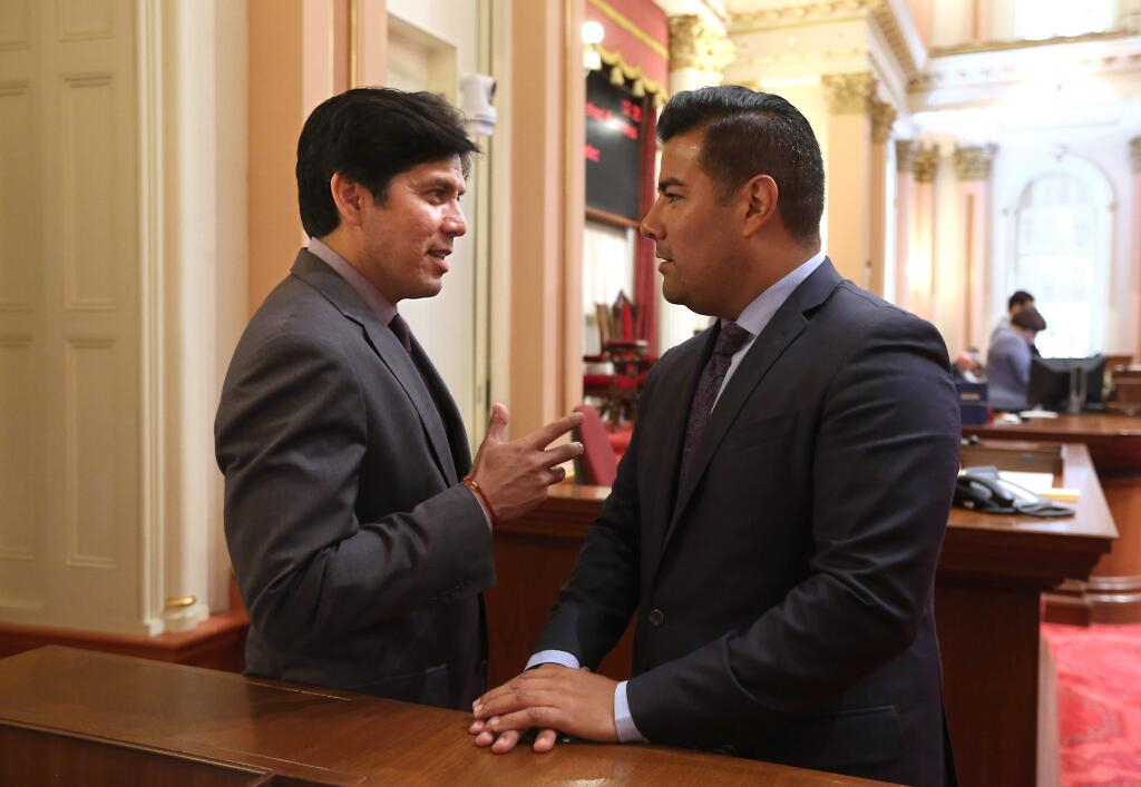 State Sen. Kevin de Leon, D-Los Angeles, left, talks with Sen. Richardo Lara, D-Bell Gardens, during the Senate session, Monday, Aug. 25, 2014, in Sacramento, Calif. By a 52-16 vote the Assembly approved de Leon's bill SB967, that changes the definition of consent for campuses investigating sexual assault cases by requiring an affirmative, unambiguous and conscious decision by each party to engage in sexual activity. That marks a shift from the popular sexual assault prevention refrain, no means no. The bill now goes back to the Senate for what is expect to be a final vote on amendments.(AP Photo/Rich Pedroncelli)