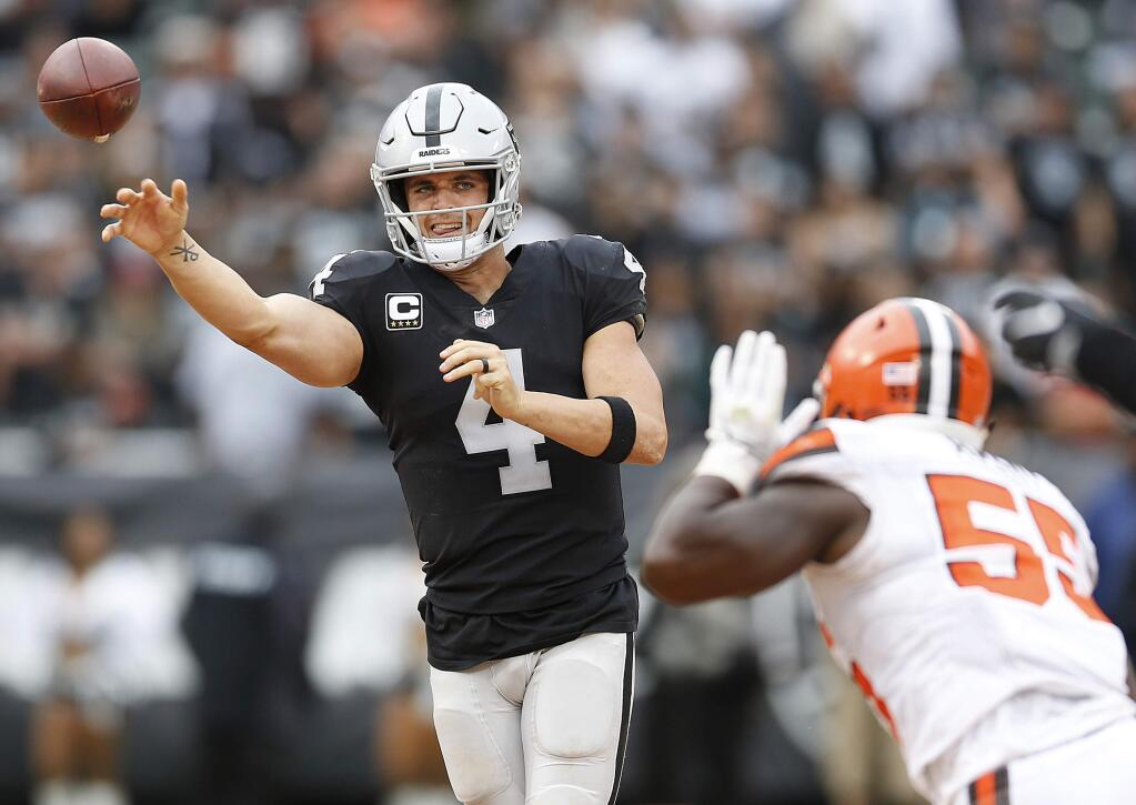 In this Sunday, Sept. 30, 2018 file photo, Oakland Raiders quarterback Derek Carr passes against Cleveland Browns linebacker Genard Avery during overtime in Oakland. (AP Photo/D. Ross Cameron, File)