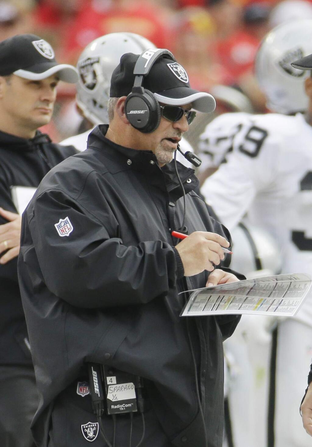 Oakland Raiders interim head coach Tony Sparano looks at notes during the first half of an NFL football game against the Kansas City Chiefs in Kansas City, Mo., Sunday, Dec. 14, 2014. (AP Photo/Charlie Riedel)