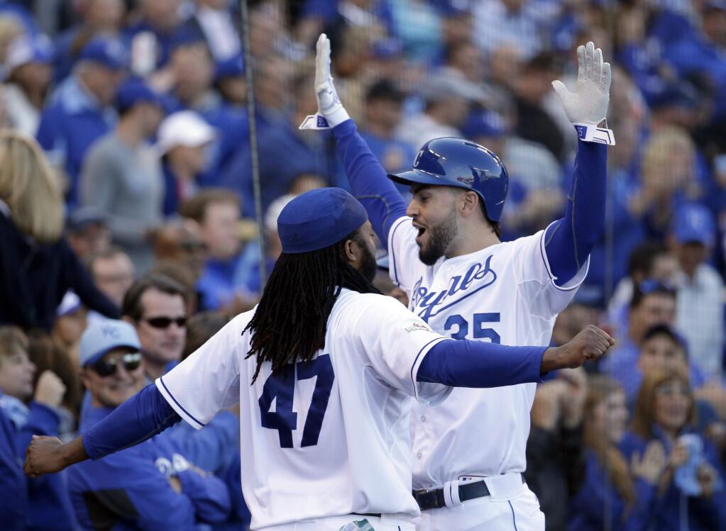 Kansas City Royals' Eric Hosmer, right, celebrates with Johnny Cueto (47) after scoring a run following a walk by teammate Salvador Perez during the sixth inning of Game 2 in baseball's American League Division Series against the Houston Astros, Friday, Oct. 9, 2015, in Kansas City, Mo. (AP Photo/Charlie Riedel)