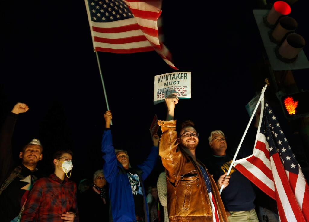 Dylan Stefanisko, at right, holds a sign that says, 'Whitaker must recuse' referencing the appointment of acting US attorney general Matthew G. Whitaker, as demonstrators in support of protecting the Mueller investigation rally outside city hall in Santa Rosa, California, on Thursday, November 8, 2018. (Alvin Jornada / The Press Democrat)
