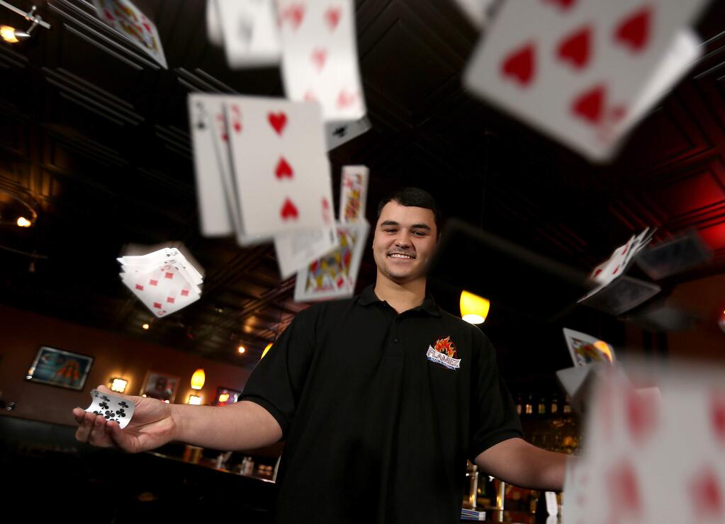 Magician Jay Shatnawi, 19, does card tricks at the Flamez Grill in Windsor every Saturday evening, Tuesday, Feb. 17, 2015. (CRISTA JEREMIASON/ PD)