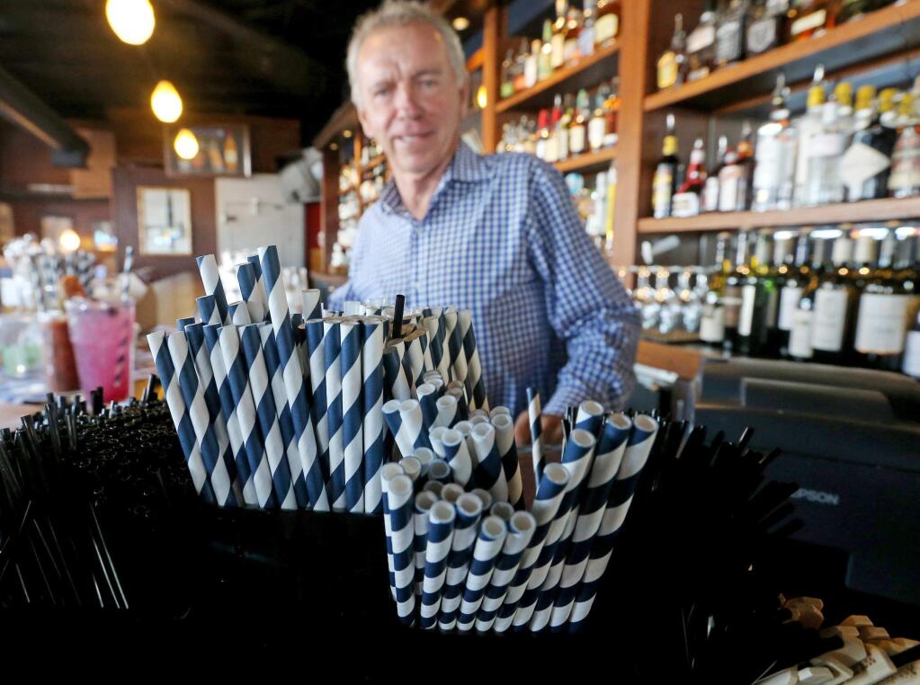 In this June 19, 2018 photo, paper straws sit at Duke Moscrip, owner of Duke's Restaurants, bar at his restaurant in Seattle. Businesses that sell food or drinks won't be allowed to offer the plastic items under a rule that went into effect Sunday, July 1. (Greg Gilbert/The Seattle Times via AP)
