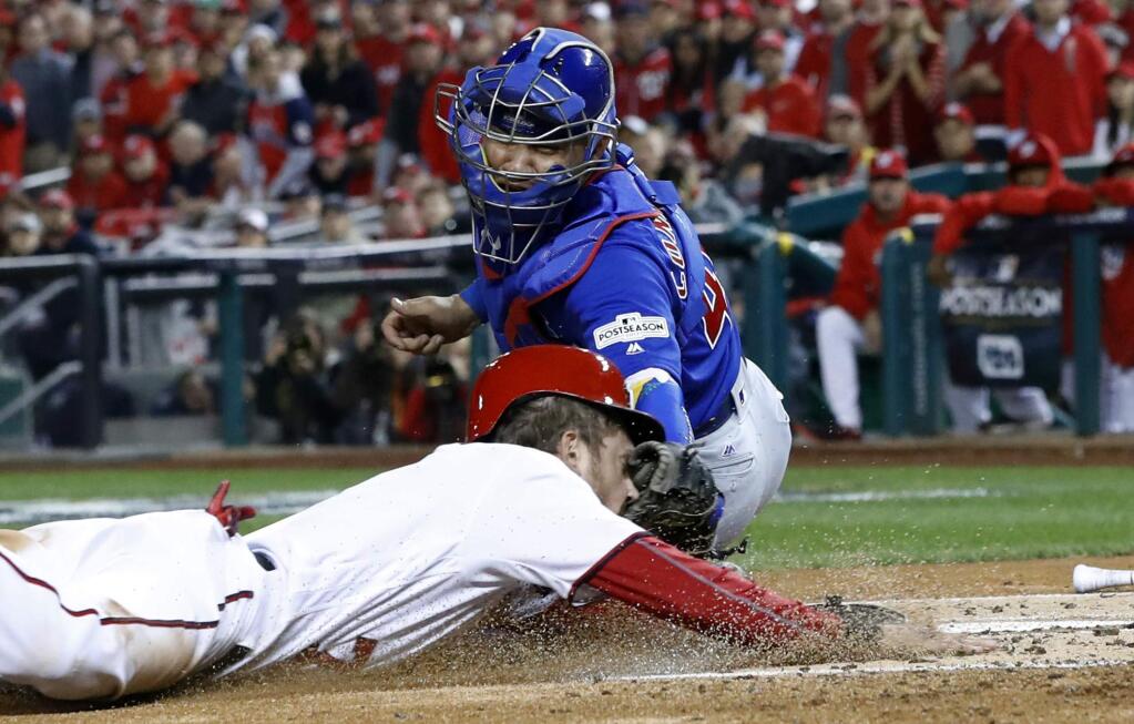 Chicago Cubs catcher Willson Contreras (40) tags out the Washington Nationals' Trea Turner (7) at home on a infield grounder by Bryce Harper during the first inning of Game 5 of the National League Division Series, at Nationals Park, Thursday, Oct. 12, 2017, in Washington. (AP Photo/Alex Brandon)