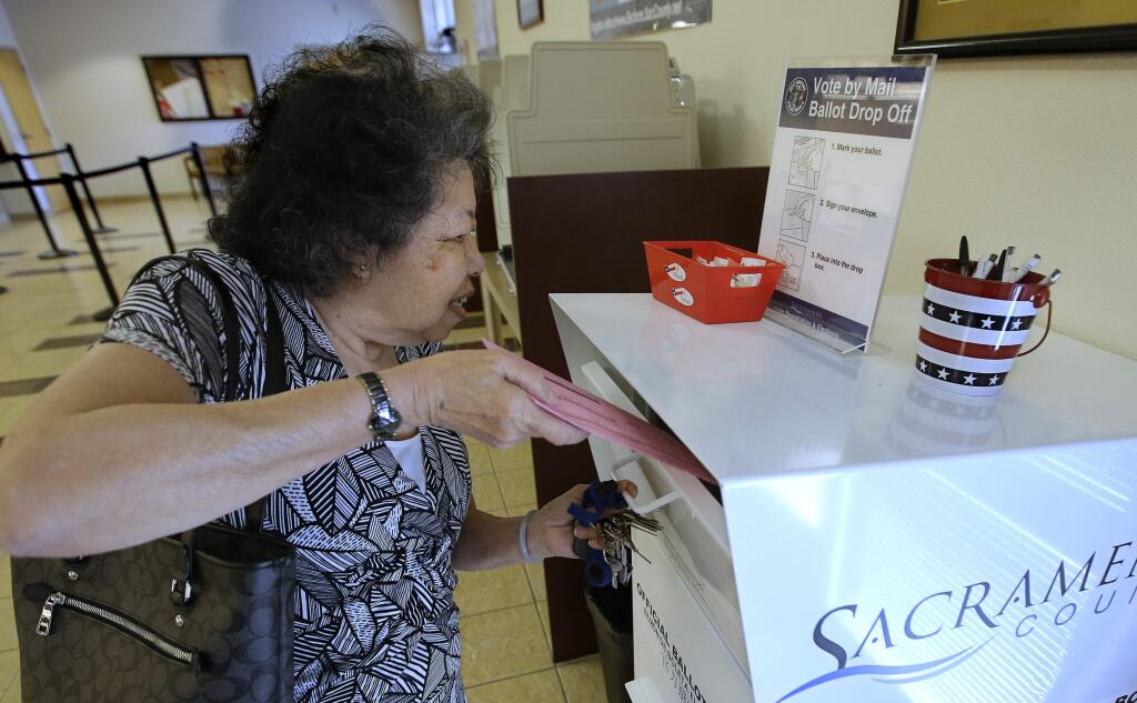 Lei Linh-Pham drops off her mail-in ballot at the Sacramento County Registrar of Voters office, Wednesday, May 30, 2018, in Sacramento, Calif. More than 1.4 million Californians have already voted absentee in the state's primary, which could have the highest ever rate of vote by mail. (AP Photo/Rich Pedroncelli)