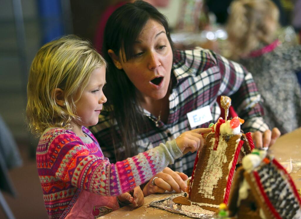 Erin Radelfinger shows her delight at the marshmallow Snoopy her daughter Mackenzie, 5, created at the Gingerbread Doghouse Workshop at the Charles M. Schulz Museum in Santa Rosa on Saturday. (JOHN BURGESS / The Press Democrat)