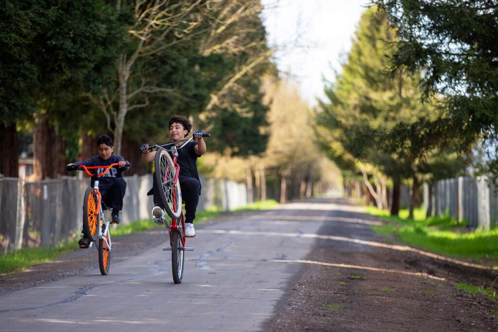Martin Acevedo, 14, right, and Alex Ortiz, 13, ride their bicycles on the Joe Rodota Trail the day it reopened to the public, in Santa Rosa, California, on Saturday, March 14, 2020. (Alvin Jornada / The Press Democrat)