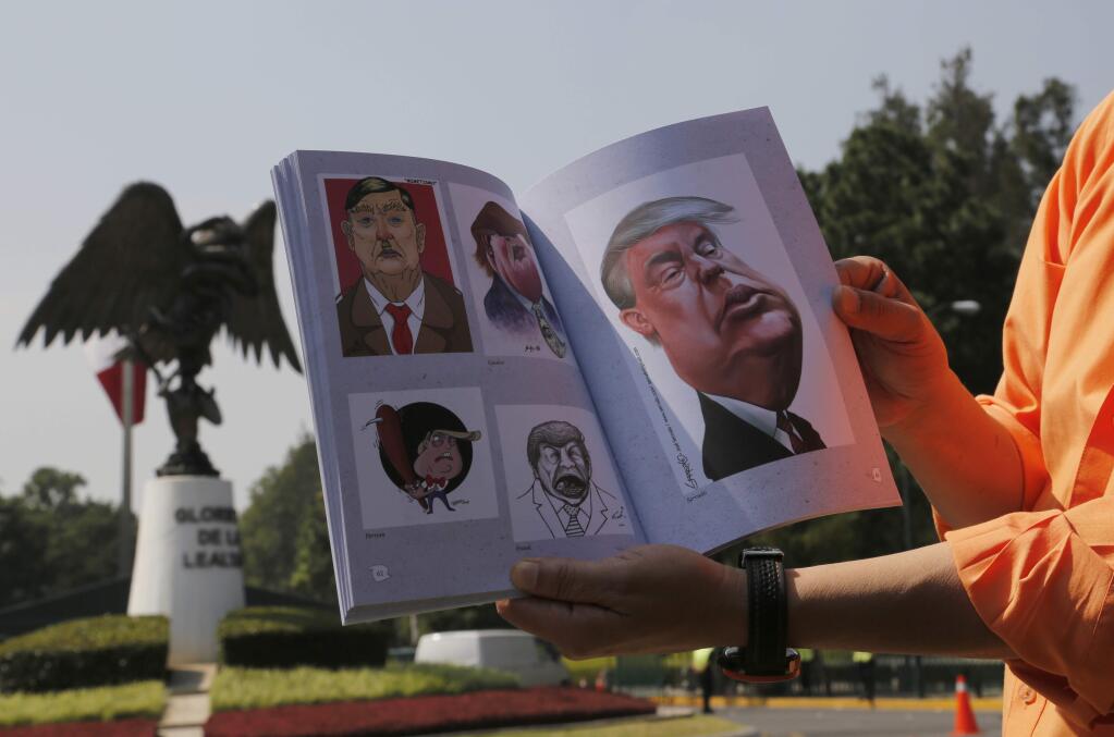 Mexican Cartoonist Arthur Kemchs shows his book of cartoons of Republican presidential candidate Donald Trump, outside of the official presidential residence of Los Pinos in Mexico City, Wednesday, Aug. 31, 2016. Kemchs went to Los Pinos with the intent to deliver a copy of his book to Trump. (AP Photo/Marco Ugarte)