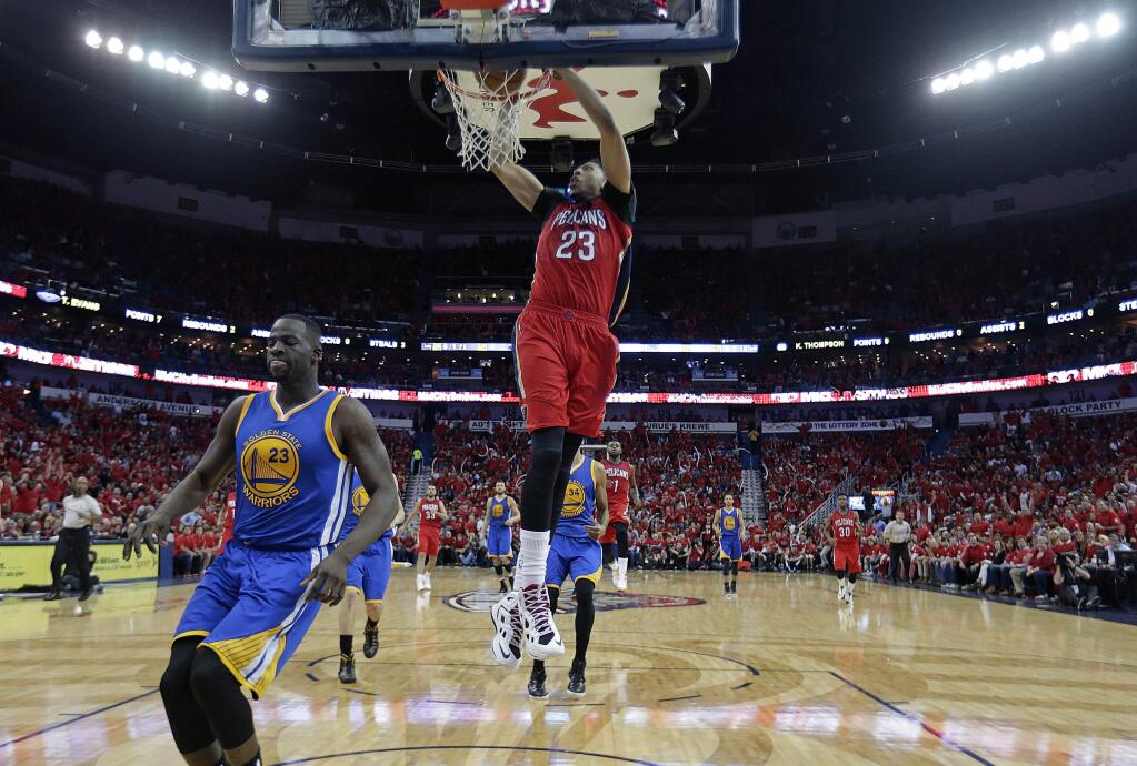 New Orleans Pelicans forward Anthony Davis (23) slam dunks over Golden State Warriors forward Draymond Green (23) during the first half of Game 3 of a first-round NBA basketball playoff series in New Orleans, Thursday, April 23, 2015. (AP Photo/Gerald Herbert)