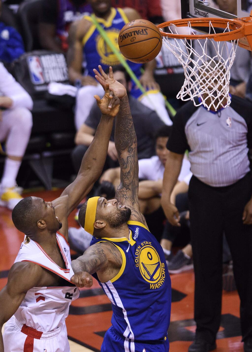Golden State Warriors' DeMarcus Cousins (0) battles for the loose ball against Toronto Raptors' Serge Ibaka (9) during the second half of Game 2 of the NBA Finals, Sunday, June 2, 2019, in Toronto. (Nathan Denette/The Canadian Press via AP)
