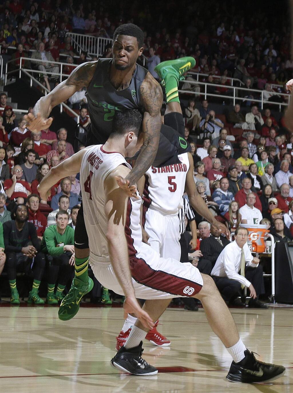 Oregon's Elgin Cook, top, knocks over Stanford's Stefan Nastic (4) during the second half of an NCAA college basketball game in Stanford, Calif., Sunday, March 1, 2015. Oregon won 73-70. (AP Photo/Jeff Chiu)