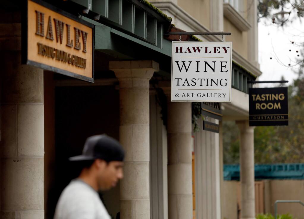 A pedestrian walks near the tasting rooms for Hawley Winery and Gustafson Family Vineyards, which are situated next door to each other on North Street in Healdsburg, California on Friday, January 29, 2016. Healdsburg city officials are again considering limiting the number of new tasting rooms around downtown. (Alvin Jornada / The Press Democrat)