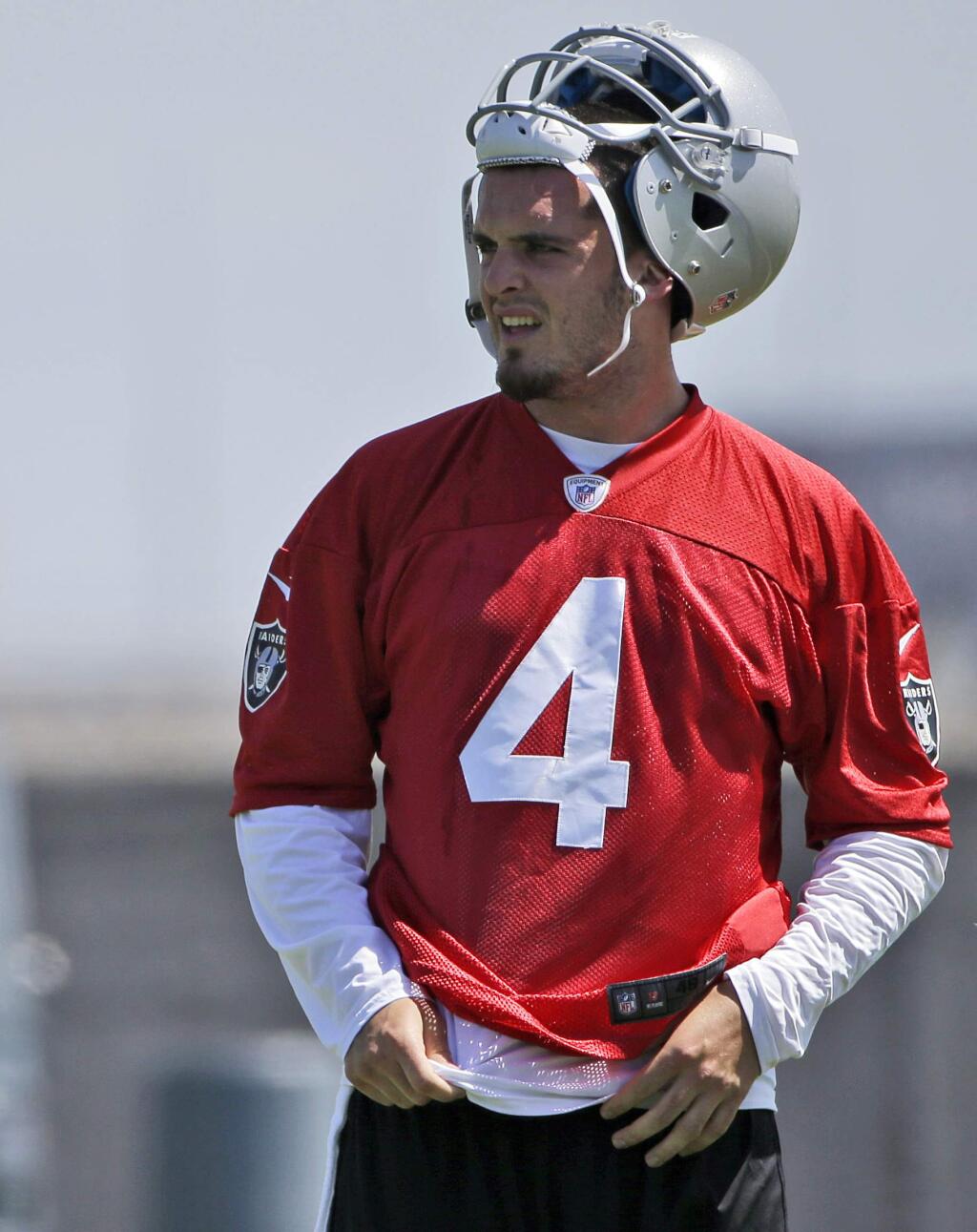 In this May 16, 2014, file photo, Oakland Raiders quarterback Derek Carr takes a break from drills during the team's NFL football rookie camp in Alameda, Calif. Twelve years after his brother David started the season opener as a rookie quarterback in Houston, Derek Carr will get the nod for the Raiders. (AP Photo/Marcio Jose Sanchez, File)