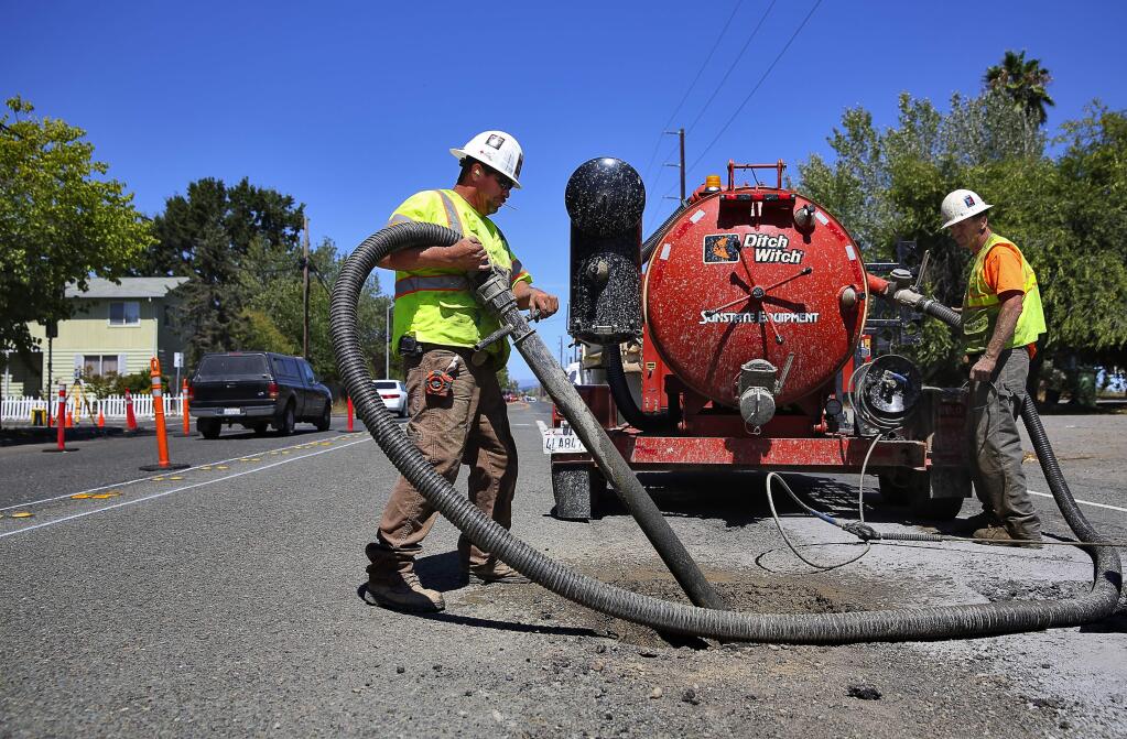Sergio Hernandes, left, and Daniel Bowman work on locating existing utilities, as work begins on the final phase of widening Stony Point Road, north of Giffen Avenue, in Santa Rosa, on Monday, Aug. 31, 2015. (Christopher Chung / The Press Democrat)
